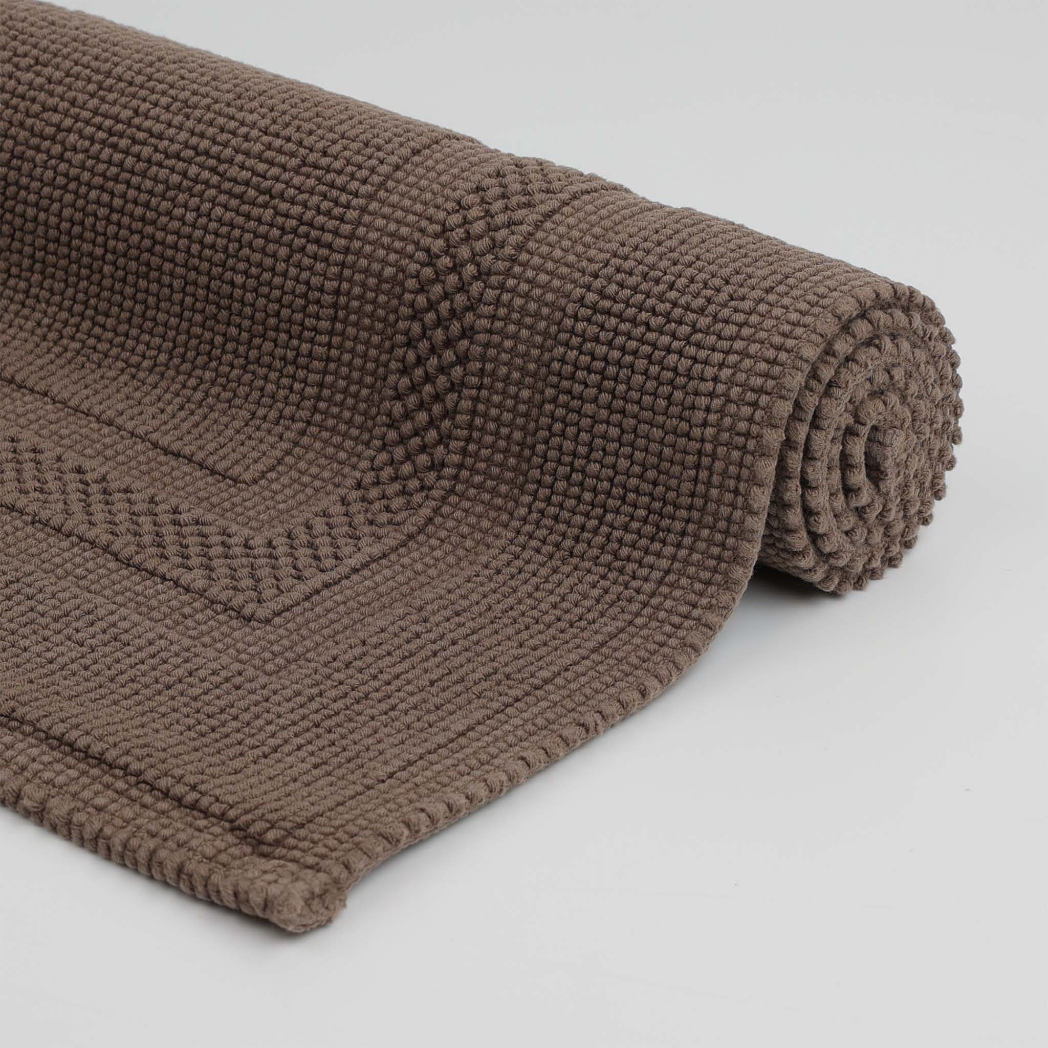 Rolle des Rhomtuft Badteppich GALA aus 100 % gewebter Baumwolle in puristischem Design mit abgesetztem Rahmen – hochwertig, langlebig und pflegeleicht