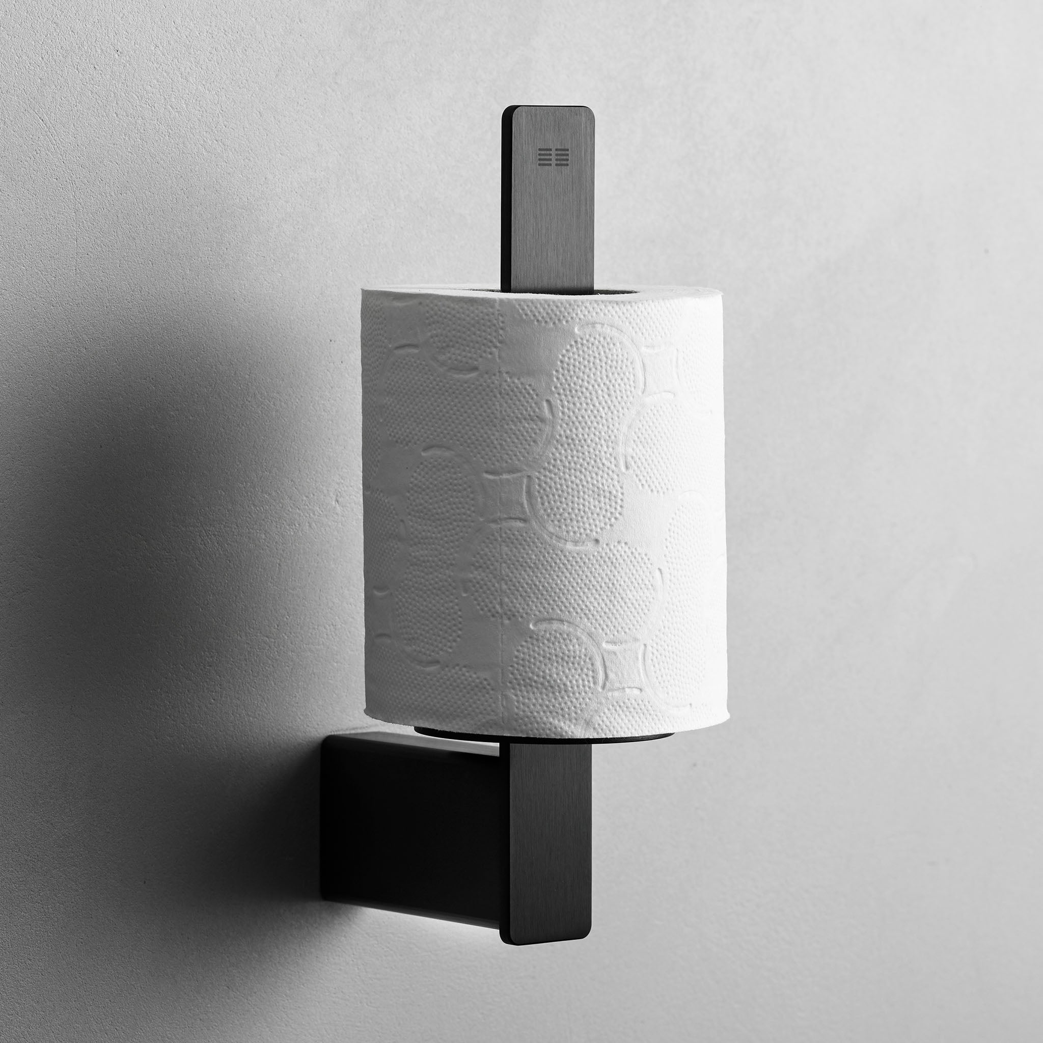 Moderner Ersatzrollenhalter in gebürstetem Schwarz – minimalistisches Accessoire für die Aufbewahrung von Toilettenpapier.