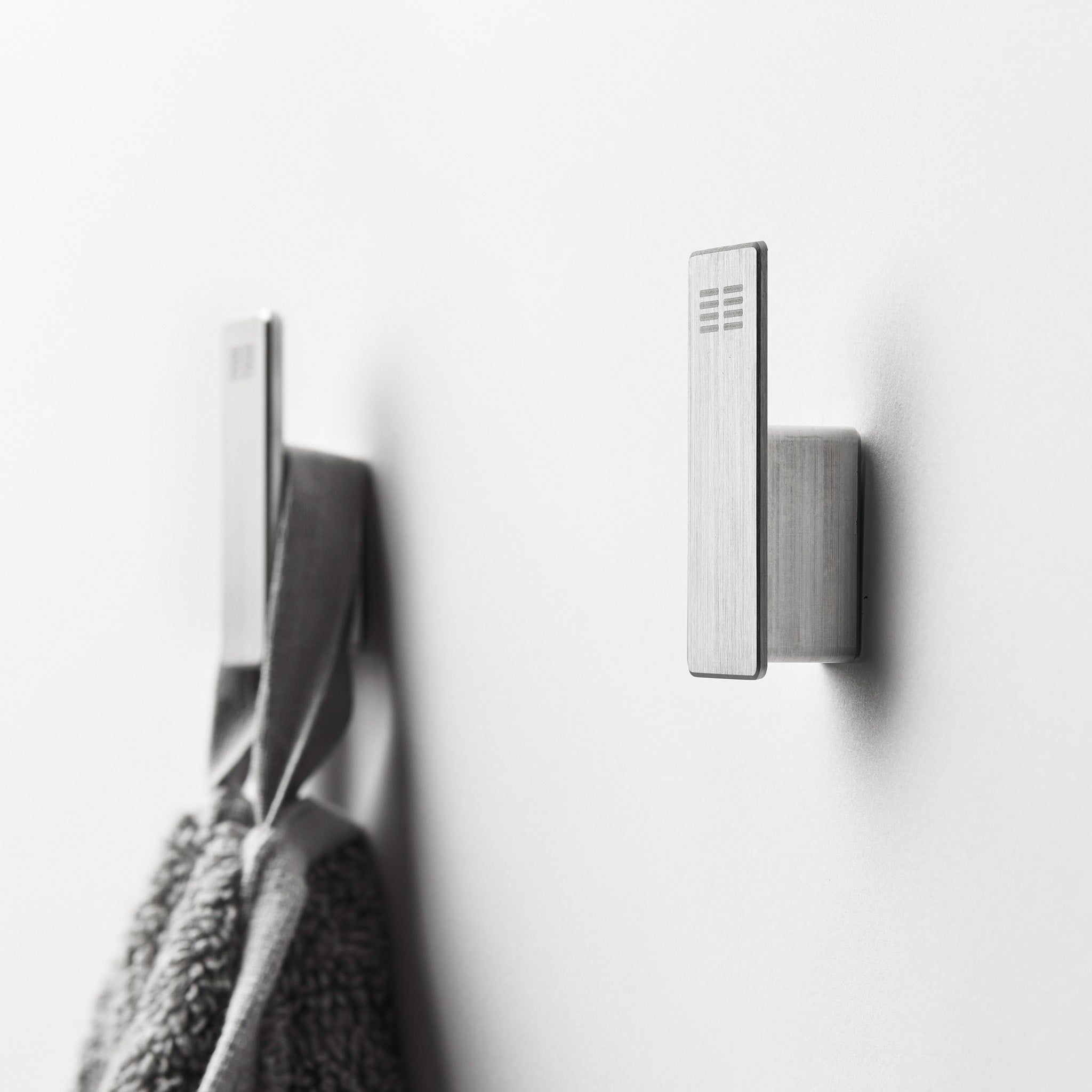 Minimalistische Handtuchhaken aus gebürstetem Edelstahl – elegante Wandhaken für Handtücher oder Bademäntel im Badezimmer.