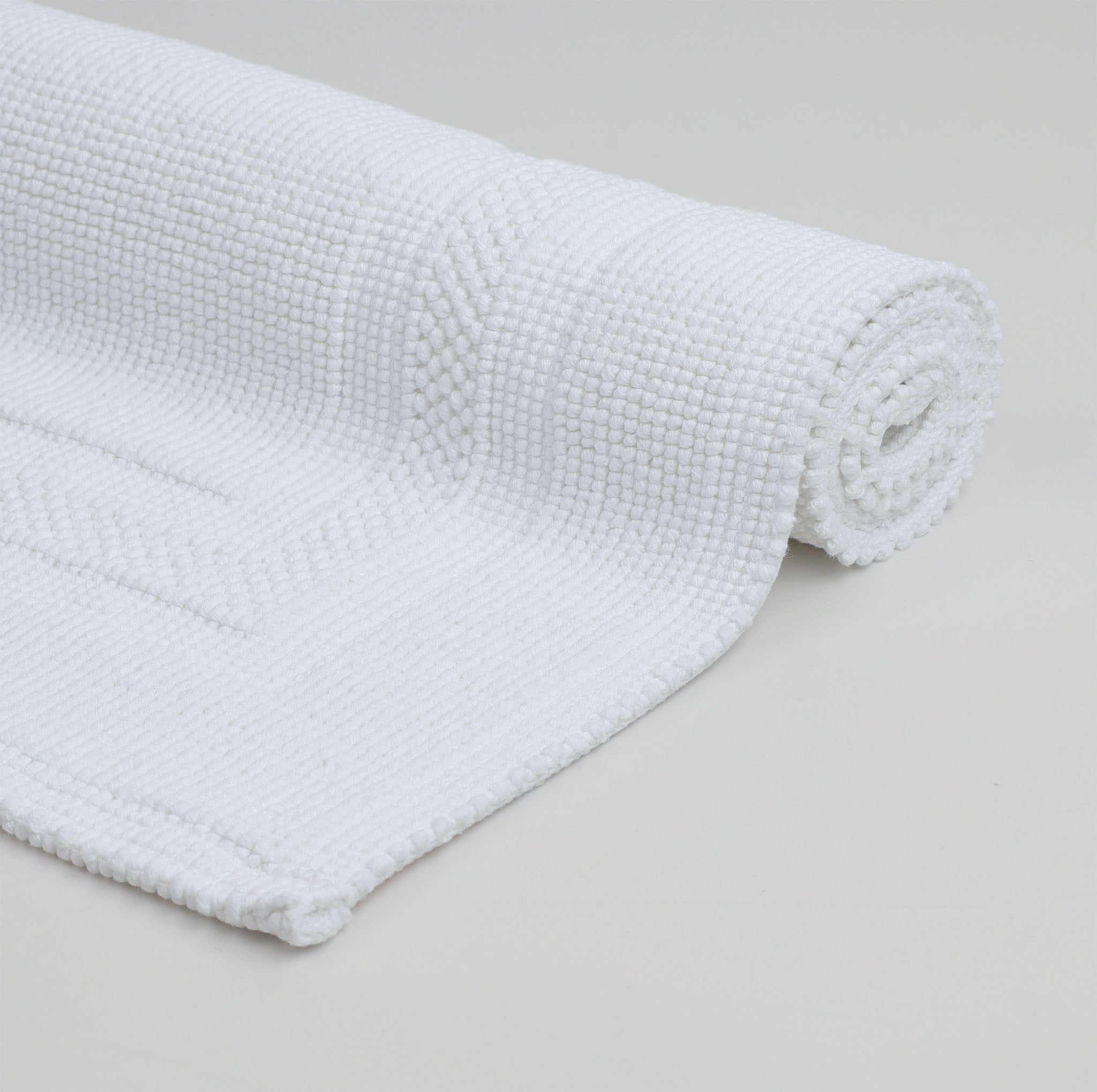 Weißer aufgerollter Rhomtuft Badteppich GALA in aus 100 % gewebter Baumwolle in puristischem Design mit abgesetztem Rahmen – hochwertig, langlebig und pflegeleicht