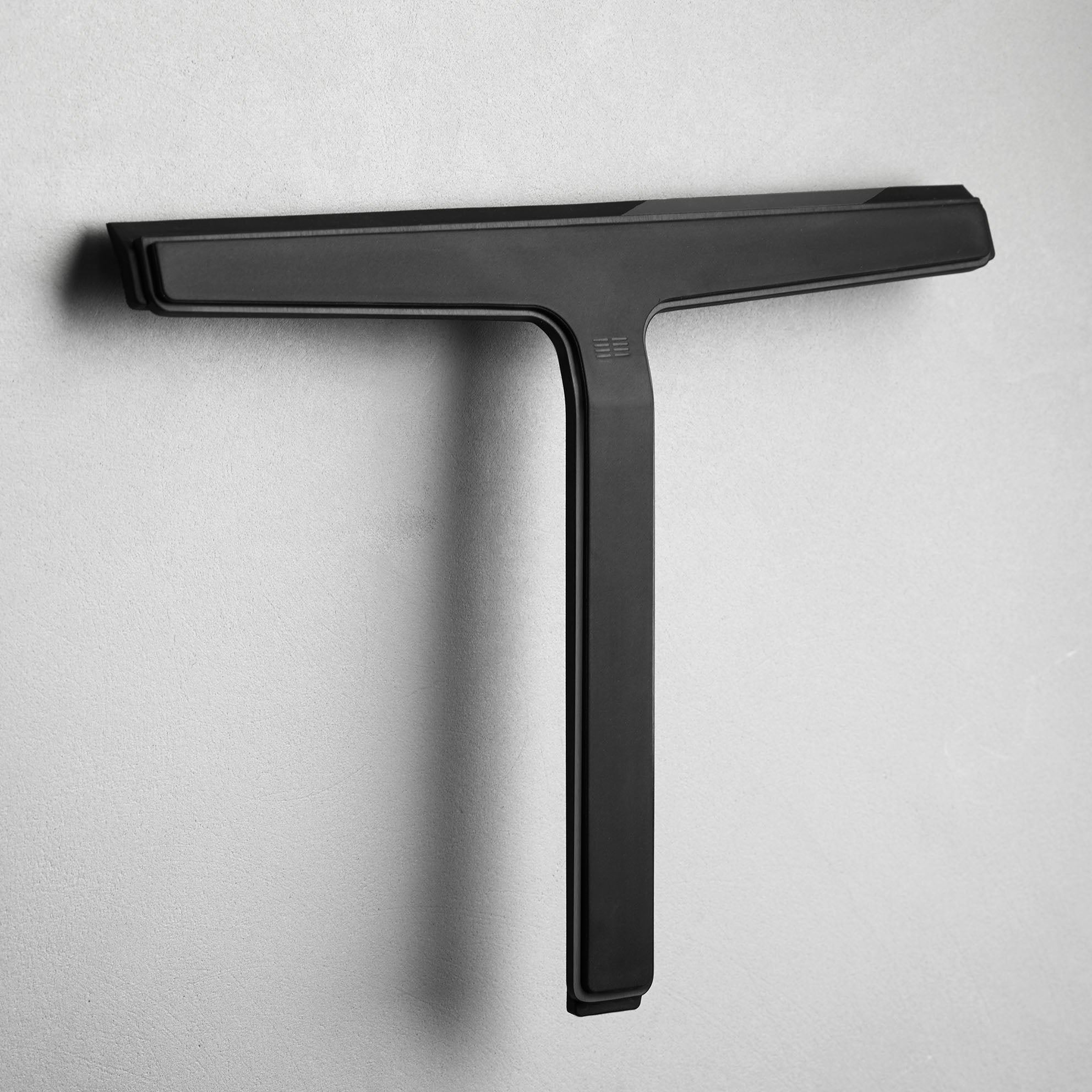 Minimalistischer Glaswischer in gebürstetem Schwarz mit cleverer Wandhalterung – elegantes Badaccessoire für die Dusche.
